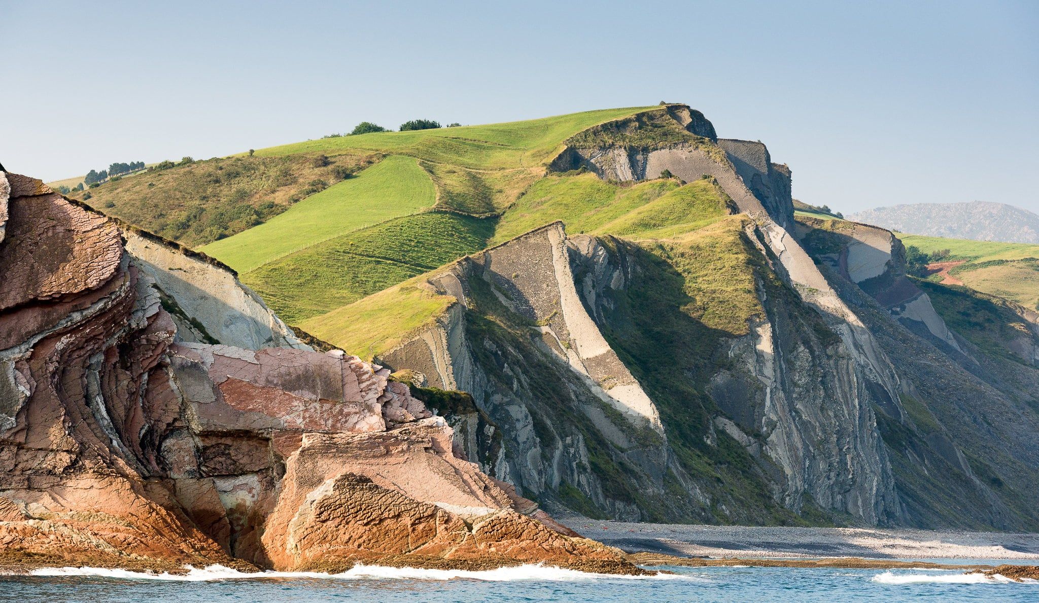 Flysch walls falling in layers onto the sand of Itzurun beach, Zumaia