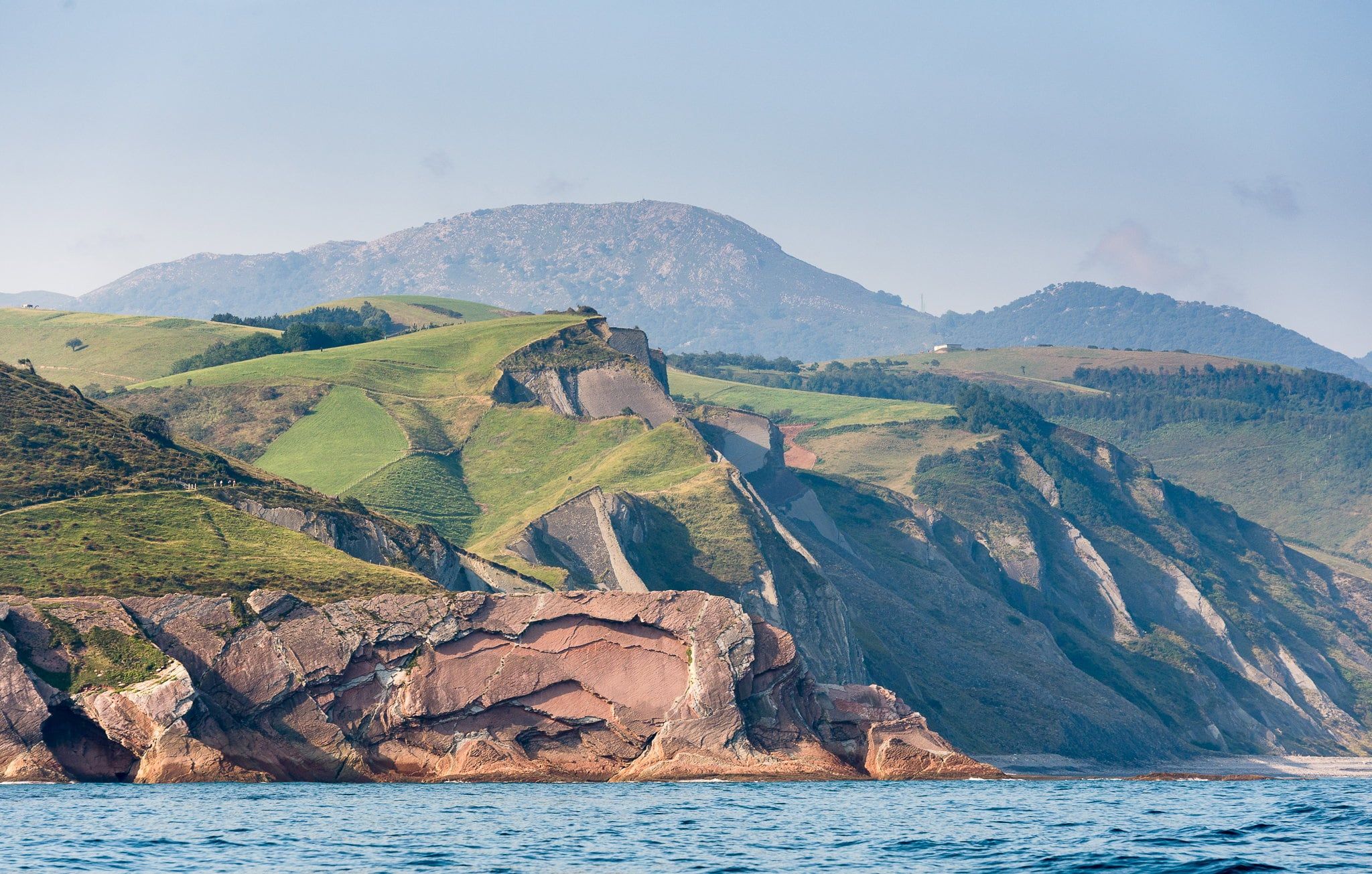 The flysch coast seen from the sea, with the cliffs and green hills of Zumaia